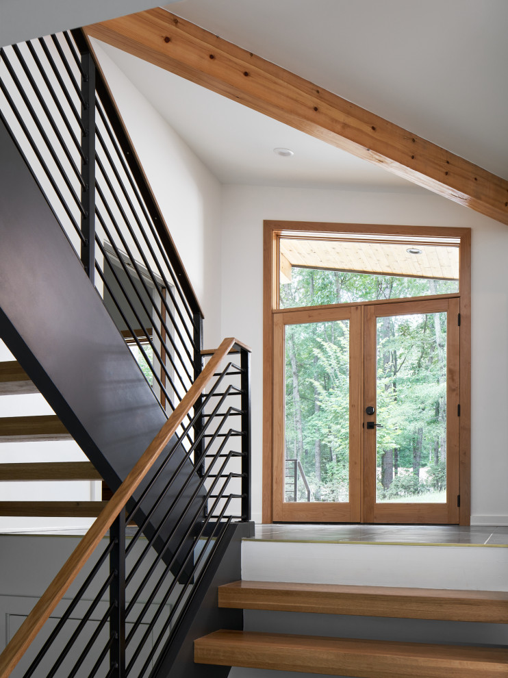 На фото: прямая лестница среднего размера в стиле ретро с деревянными ступенями и перилами из смешанных материалов без подступенок с
