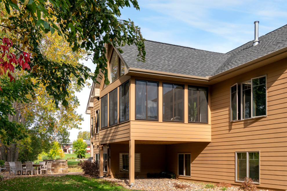 Modelo de fachada de casa beige y gris clásica grande de dos plantas con revestimiento de madera, tejado a dos aguas, tejado de teja de madera y teja
