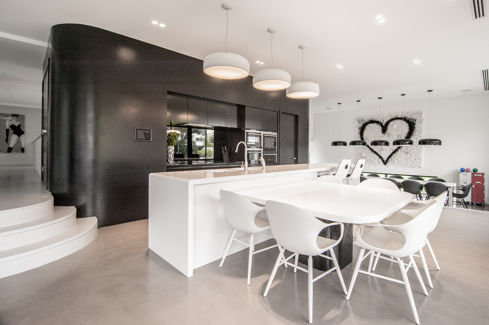 Design ideas for a mid-sized contemporary single-wall eat-in kitchen in Sydney with an integrated sink, flat-panel cabinets, black cabinets, with island and solid surface benchtops.