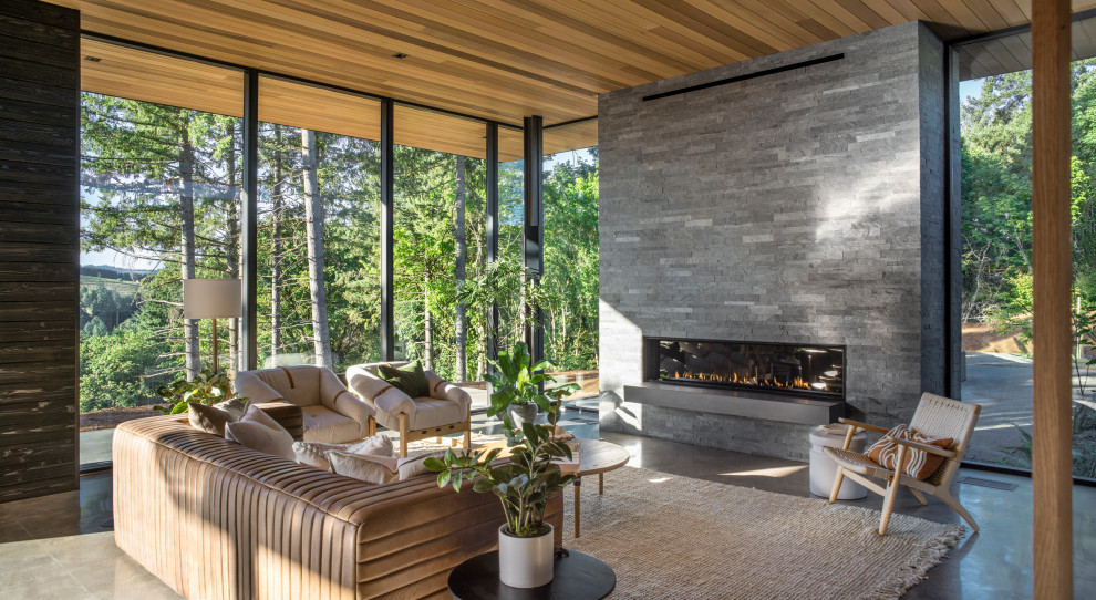 Свежая идея для дизайна: открытая гостиная комната в стиле модернизм с бетонным полом, горизонтальным камином, фасадом камина из камня и деревянными стенами - отличное фото интерьера