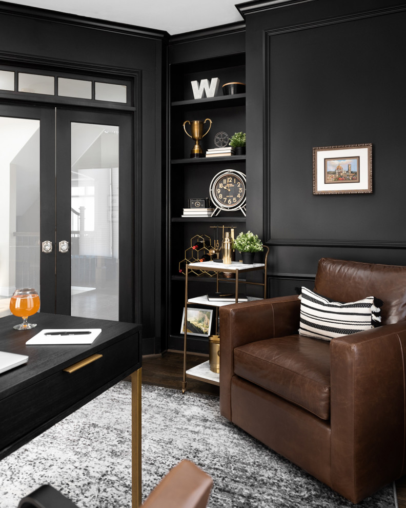 Large transitional study room in Chicago with black walls, dark hardwood floors, a two-sided fireplace, a stone fireplace surround, a freestanding desk and decorative wall panelling.