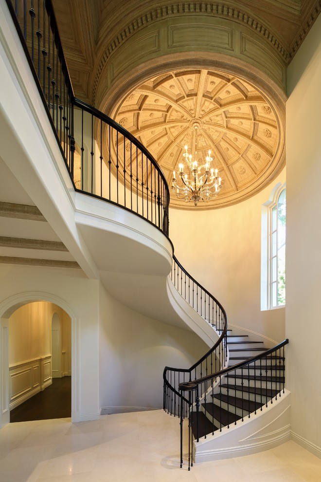 This is an example of a large traditional wood spiral staircase in Los Angeles with painted wood risers and mixed railing.