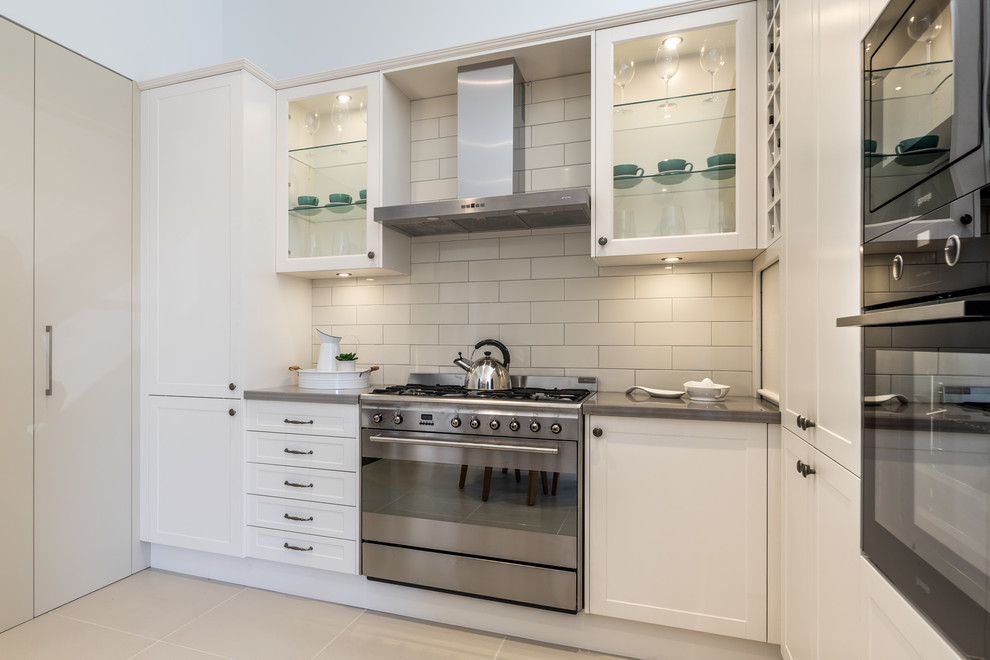 Small contemporary u-shaped separate kitchen in Sydney with a double-bowl sink, shaker cabinets, white cabinets, granite benchtops, white splashback, subway tile splashback, white appliances and no island.
