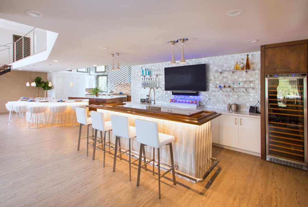 Design ideas for a contemporary seated home bar in San Francisco with flat-panel cabinets, white cabinets, multi-coloured splashback, mosaic tile splashback and light hardwood floors.