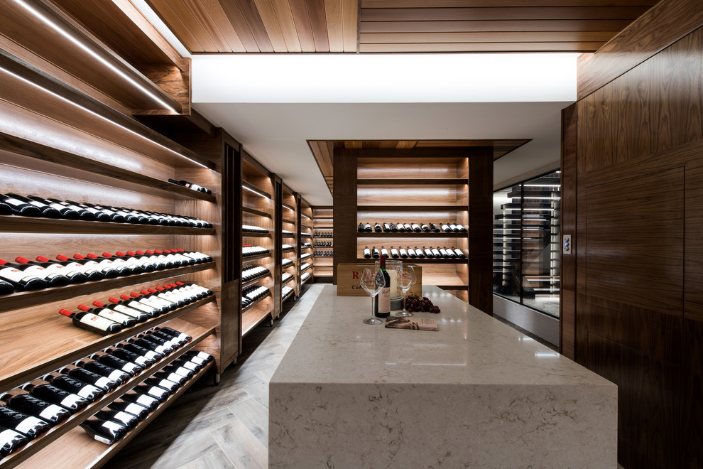 Tropical wine cellar in Perth with light hardwood floors, display racks and beige floor.