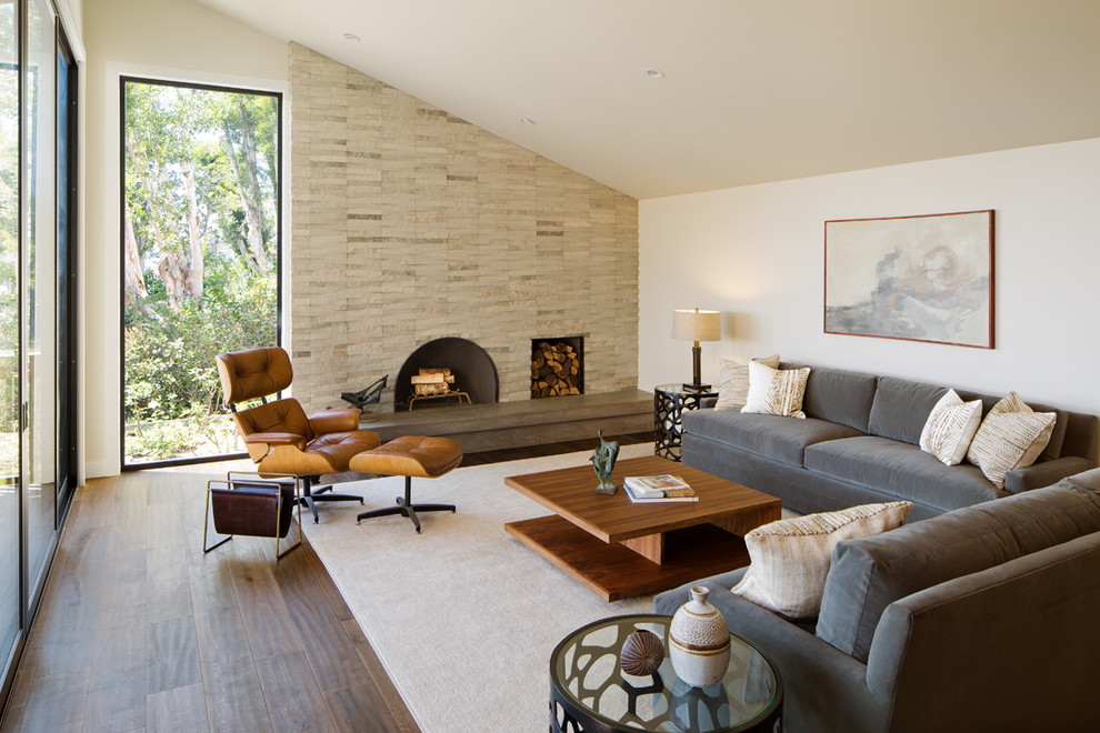 This is an example of a contemporary formal open concept living room in San Diego with beige walls, dark hardwood floors, a standard fireplace, a stone fireplace surround and no tv.