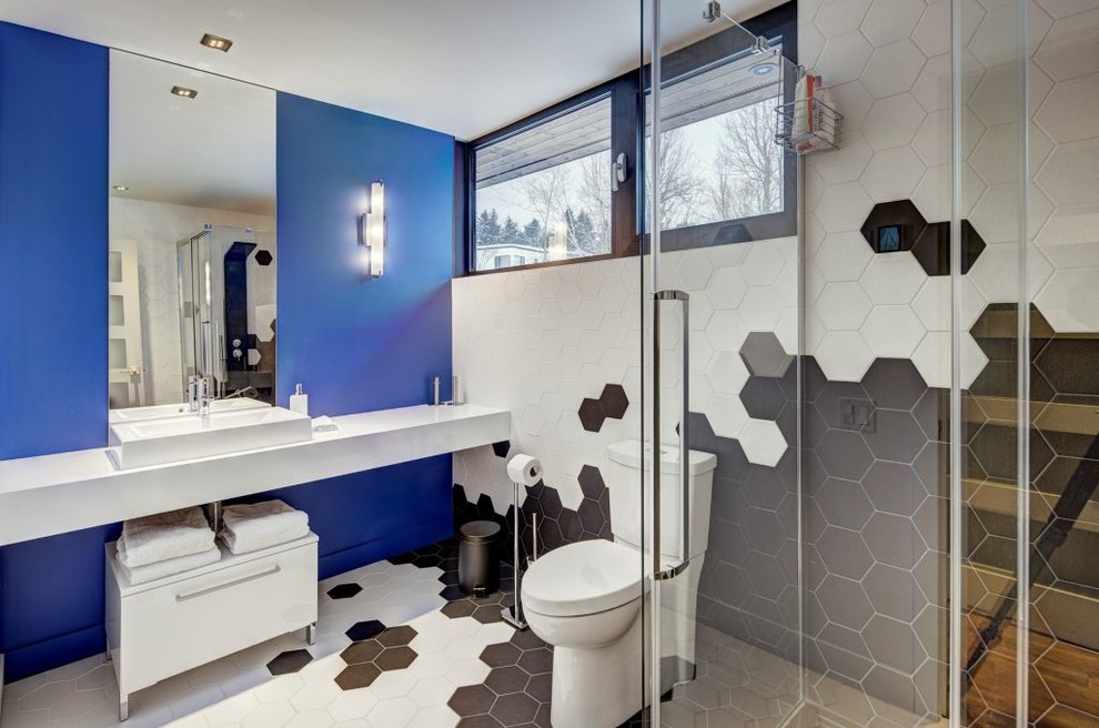 Photo of a contemporary 3/4 bathroom in Montreal with a vessel sink, flat-panel cabinets, white cabinets, a two-piece toilet, multi-coloured tile and multi-coloured walls.