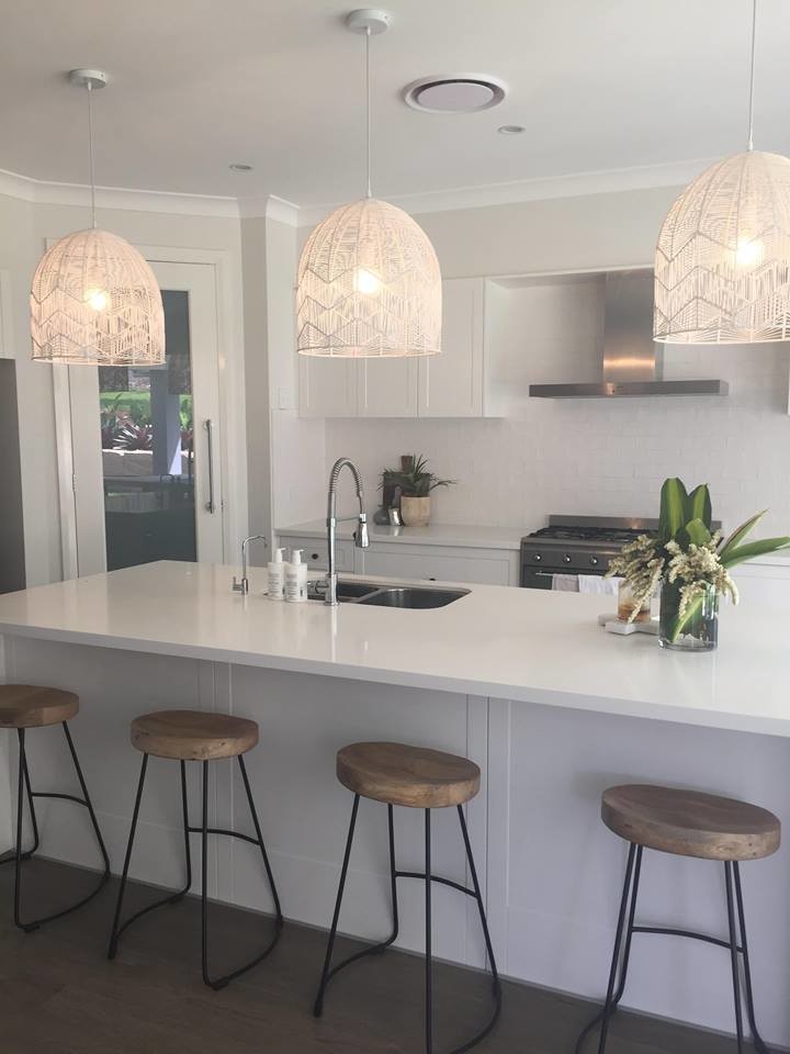 Inspiration for an expansive contemporary galley open plan kitchen in Sydney with a double-bowl sink, shaker cabinets, white cabinets, quartz benchtops, white splashback, porcelain splashback, stainless steel appliances, medium hardwood floors, with island, brown floor and white benchtop.