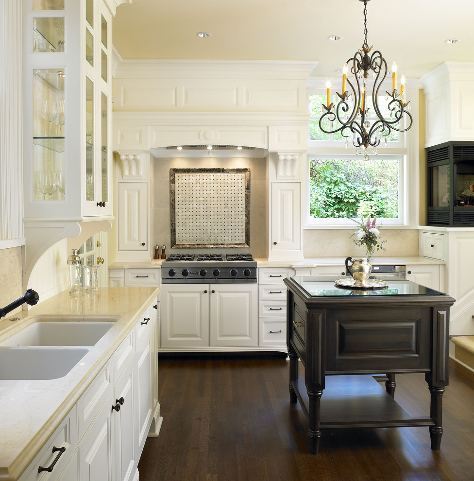 Traditional kitchen in Vancouver with a double-bowl sink, raised-panel cabinets and white cabinets.