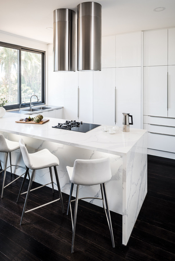 This is an example of a mid-sized modern u-shaped eat-in kitchen in Melbourne with an integrated sink, flat-panel cabinets, white cabinets, quartz benchtops, black appliances, dark hardwood floors, a peninsula, black floor and yellow benchtop.