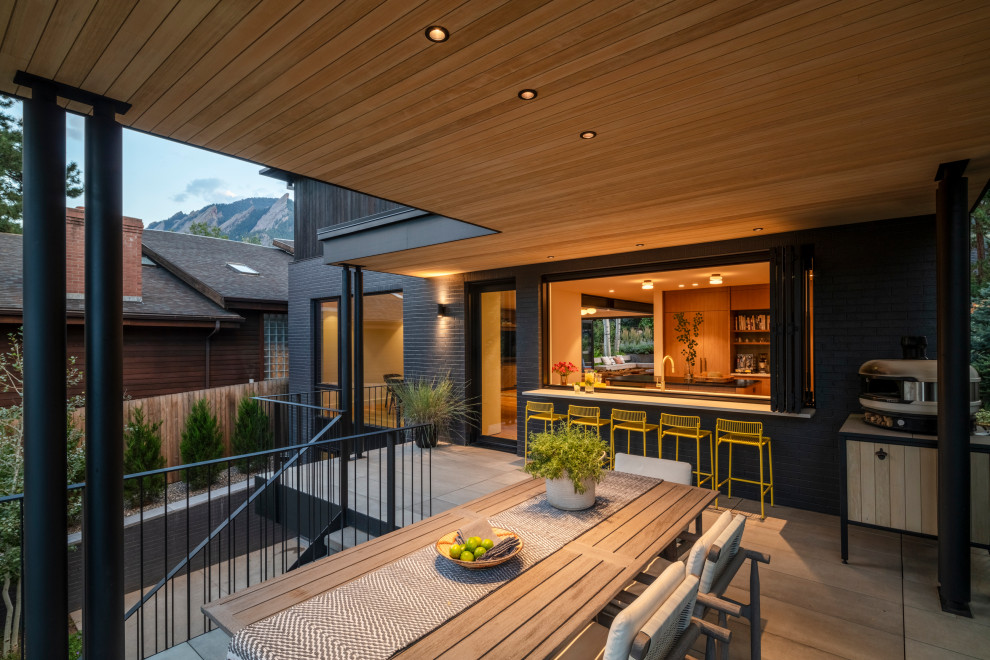 Inspiration för moderna terrasser, med takförlängning och räcke i metall