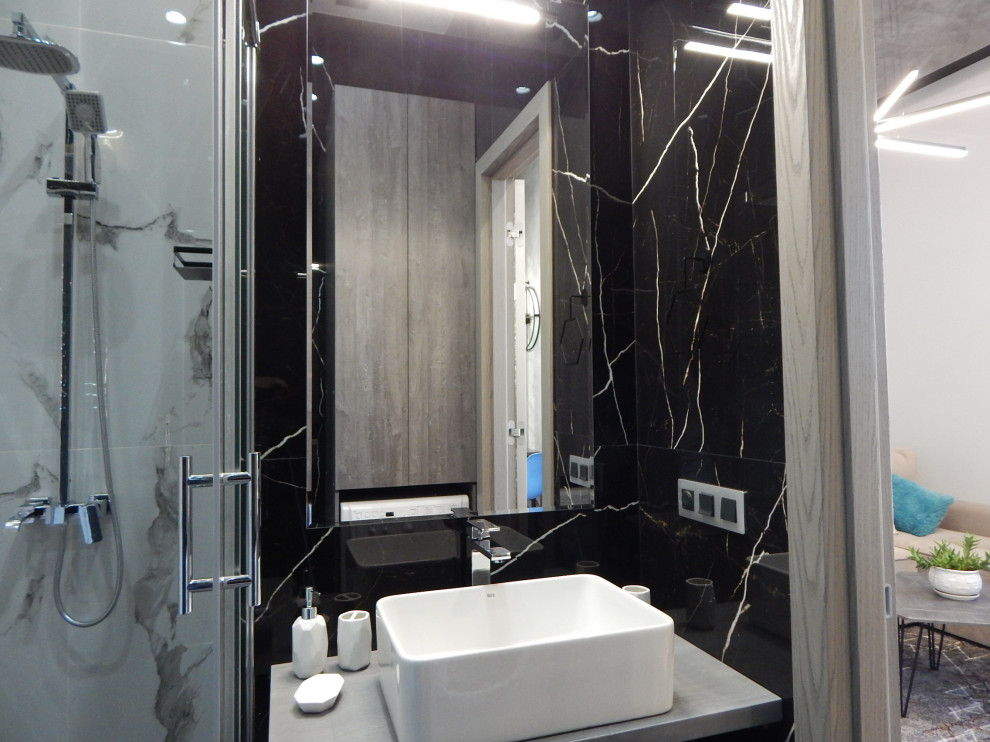 Photo of a mid-sized contemporary 3/4 bathroom in Moscow with flat-panel cabinets, dark wood cabinets, a corner shower, a wall-mount toilet, black and white tile, porcelain tile, porcelain floors, a drop-in sink, solid surface benchtops, grey floor, a sliding shower screen, grey benchtops, a laundry, a single vanity, a floating vanity and recessed.