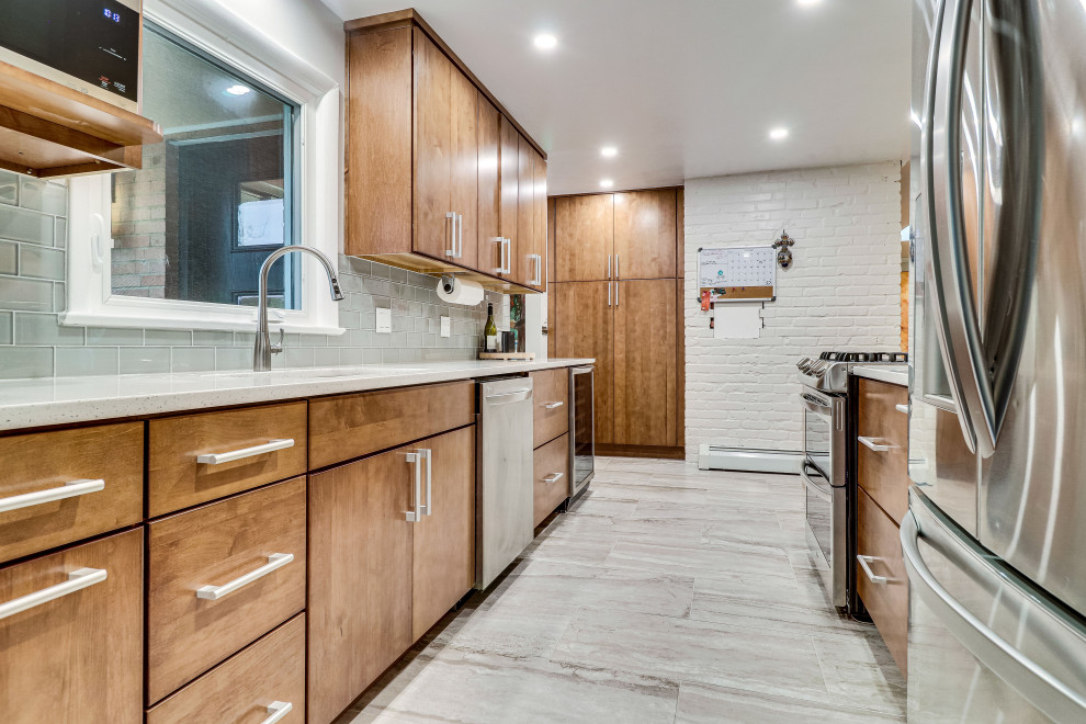 This is an example of a mid-sized midcentury galley kitchen in DC Metro with an undermount sink, quartz benchtops, stainless steel appliances and a peninsula.