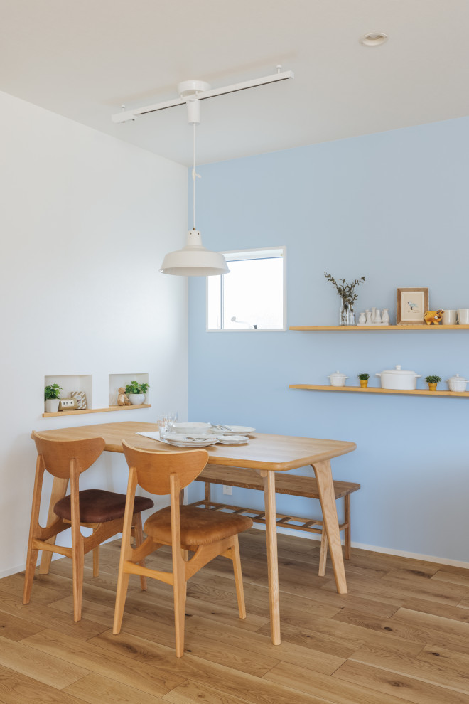 Exemple d'une petite salle à manger ouverte sur le salon scandinave avec un mur bleu, parquet clair, un sol beige, un plafond en papier peint et du papier peint.