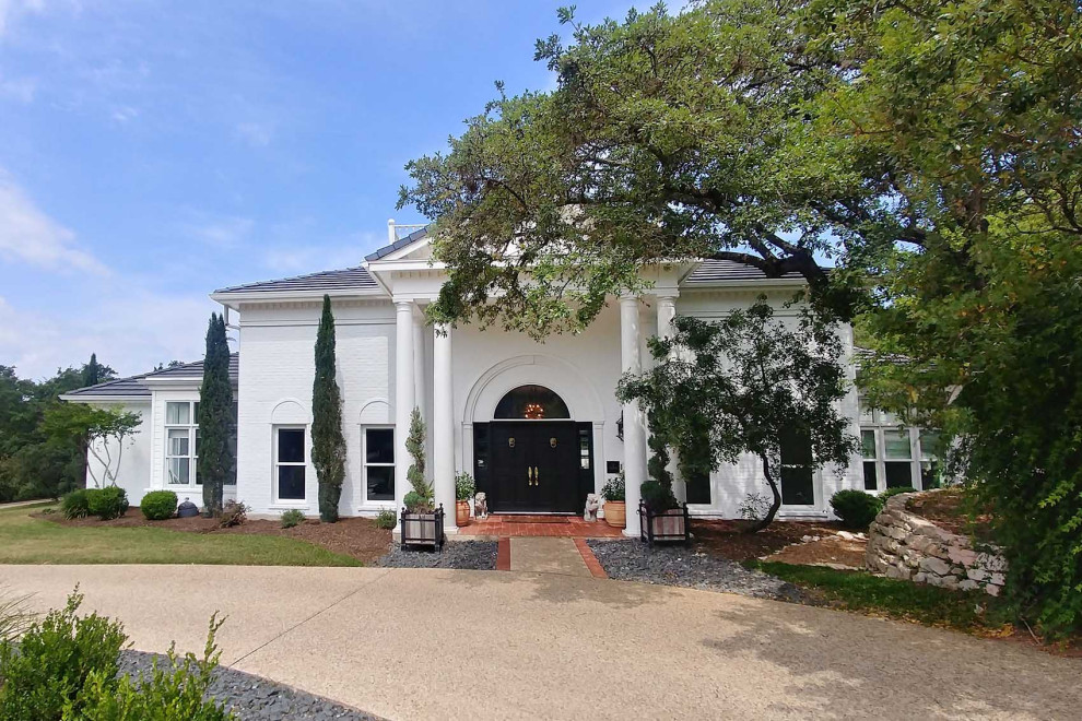 Photo of an expansive traditional two-storey brick white house exterior in Austin with a gable roof.