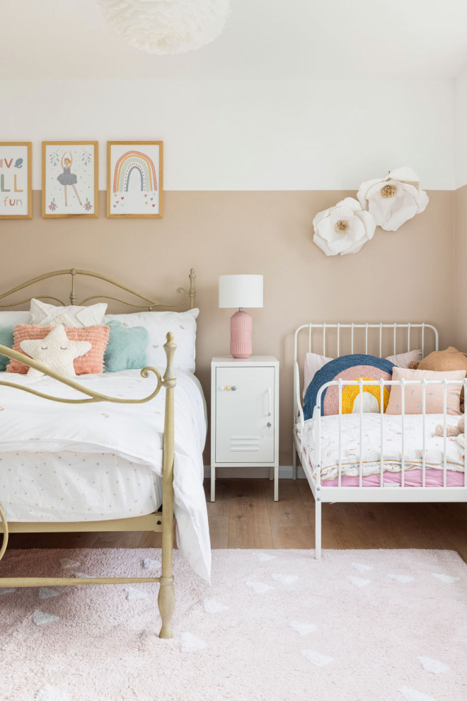 Imagen de dormitorio infantil de 4 a 10 años campestre de tamaño medio con paredes rosas, suelo de madera clara y suelo beige
