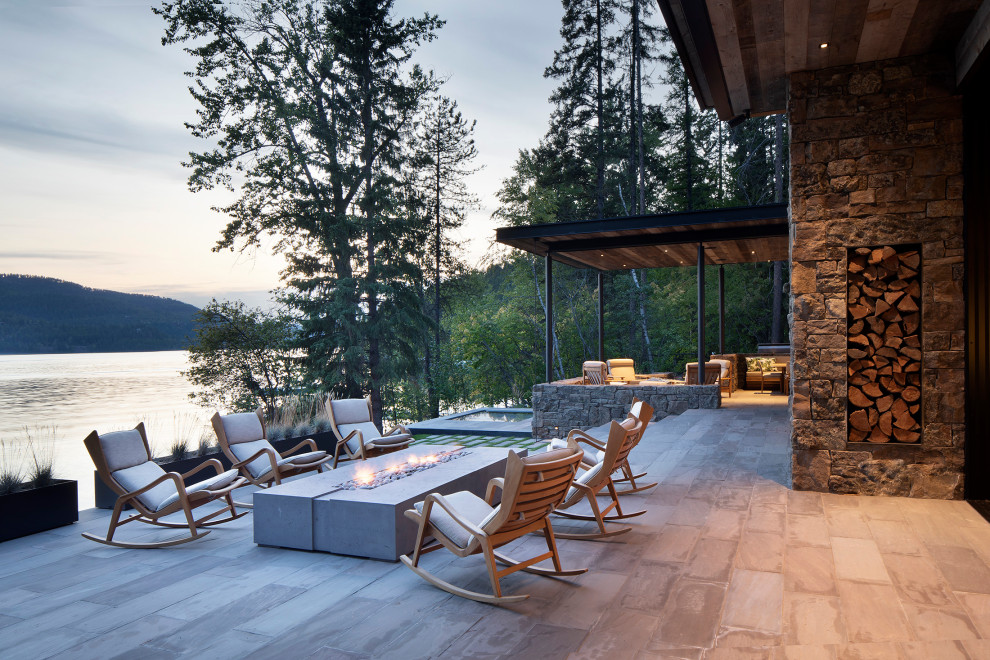 Inspiration for a mid-sized country backyard patio in Other with a fire feature and natural stone pavers.