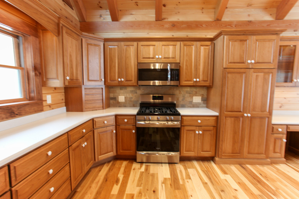 Eat-in kitchen - rustic u-shaped light wood floor, yellow floor and wood ceiling eat-in kitchen idea with a double-bowl sink, raised-panel cabinets, medium tone wood cabinets, wood backsplash, stainless steel appliances, an island and white countertops
