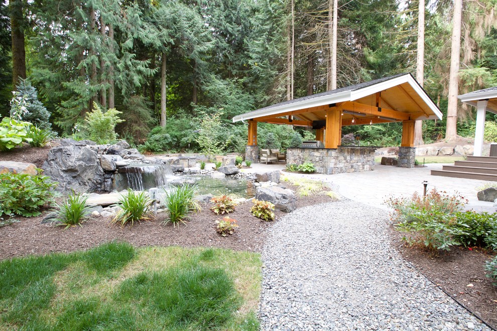 This is an example of a large contemporary backyard garden in Seattle with concrete pavers.