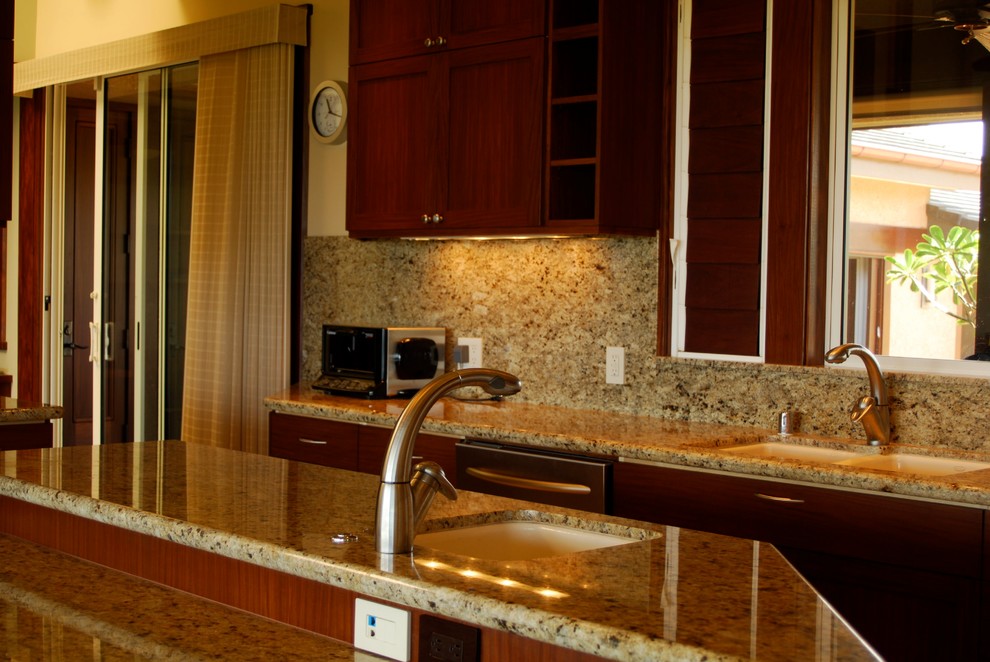 Photo of a mid-sized tropical u-shaped eat-in kitchen in Hawaii with an undermount sink, shaker cabinets, dark wood cabinets, granite benchtops, stone slab splashback, stainless steel appliances, ceramic floors, with island, brown floor, beige splashback and beige benchtop.