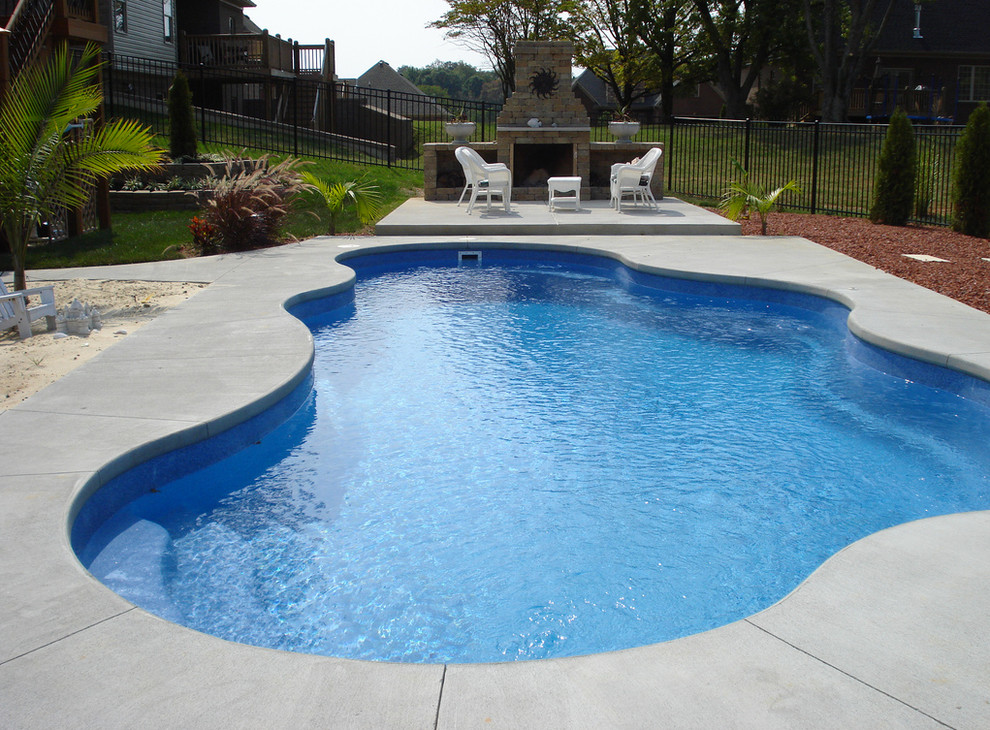 Example of a large backyard concrete and custom-shaped natural pool design in Cincinnati