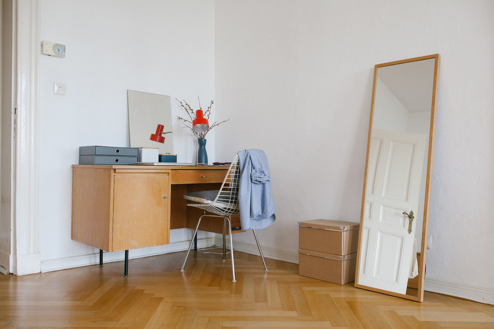 Photo of a midcentury study room in Berlin with white walls, light hardwood floors, a freestanding desk and no fireplace.