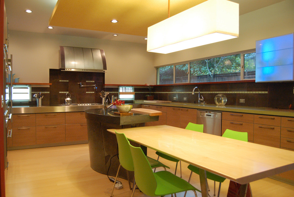 Photo of a contemporary u-shaped eat-in kitchen in San Francisco with an undermount sink, flat-panel cabinets, medium wood cabinets, concrete benchtops, stainless steel appliances, light hardwood floors and brown floor.