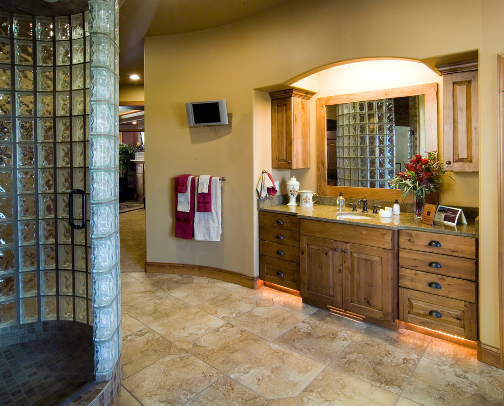 Design ideas for a large traditional master bathroom in Other with raised-panel cabinets, medium wood cabinets, an alcove shower, a two-piece toilet, beige walls, ceramic floors, an undermount sink, granite benchtops, beige floor and a hinged shower door.