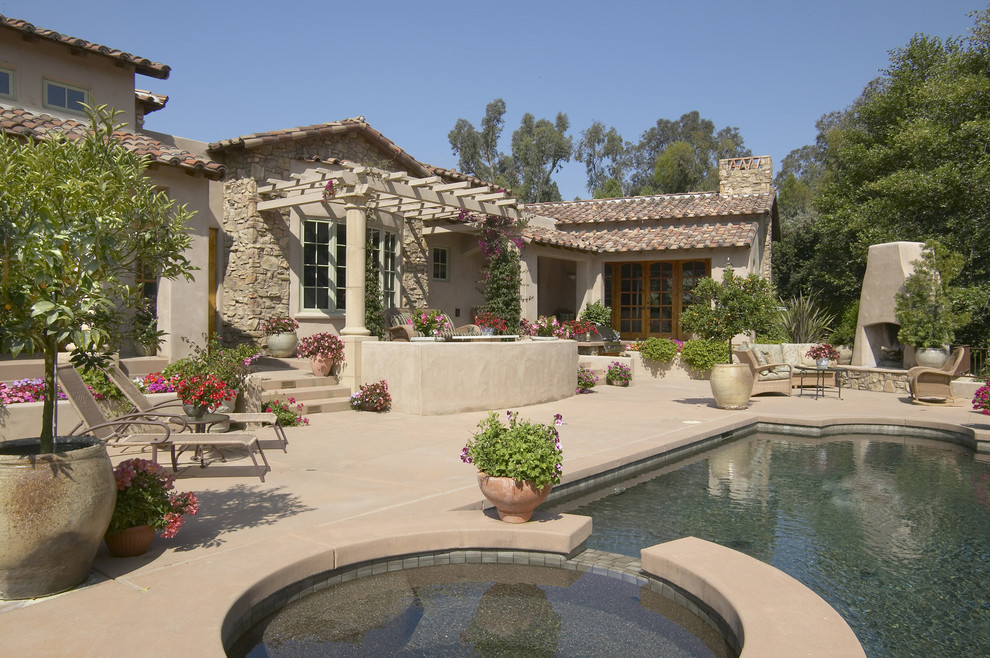 This is an example of a mediterranean custom-shaped pool in San Diego with a hot tub and concrete pavers.