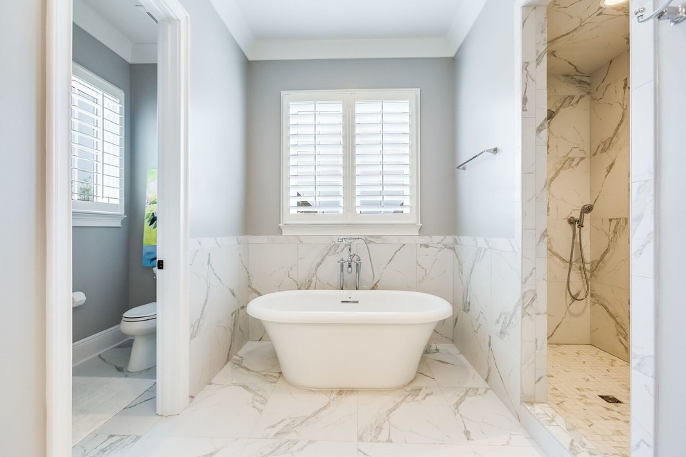Photo of a traditional master bathroom in Birmingham with shaker cabinets, white cabinets, a freestanding tub, an open shower, a two-piece toilet, black and white tile, ceramic tile, grey walls, ceramic floors, an undermount sink, engineered quartz benchtops, white floor and an open shower.