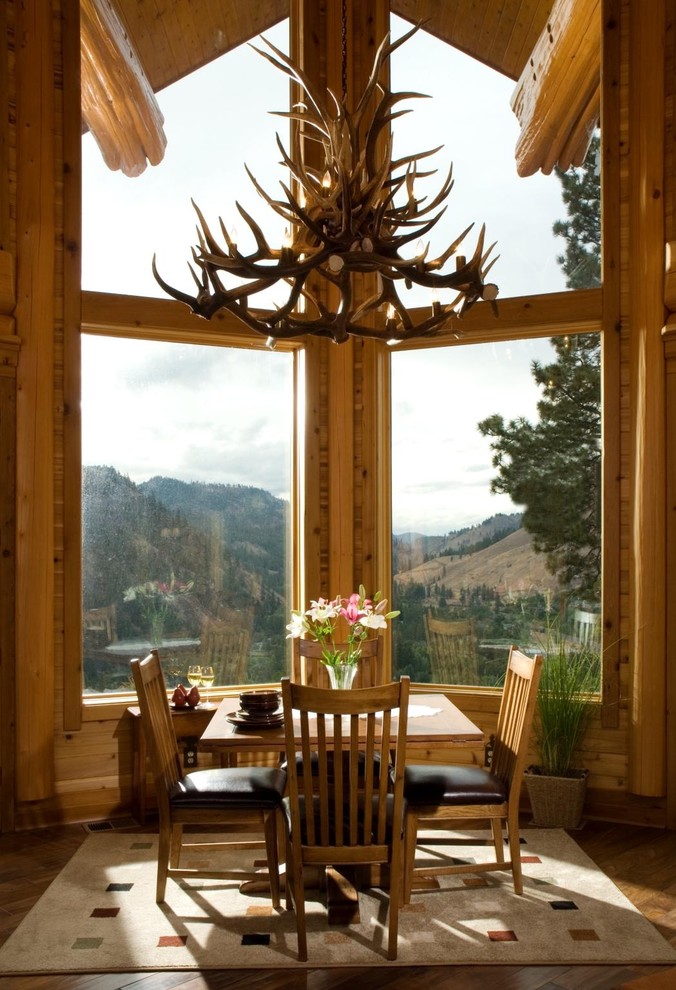 This is an example of a country dining room in Boise with dark hardwood floors.