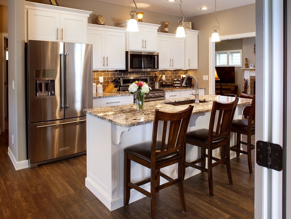 Inspiration for a small single-wall kitchen remodel with flat-panel cabinets, white cabinets, stainless steel appliances and an island