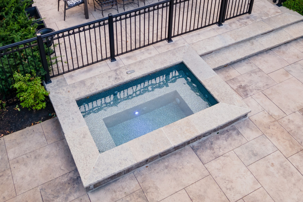 Hot tub - mid-sized transitional backyard stamped concrete and rectangular hot tub idea in Toronto