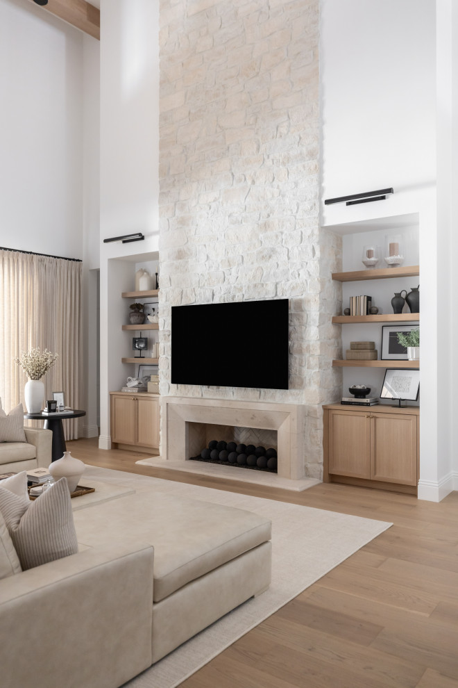 Worth the Wait - Inspiration for a transitional medium tone wood floor and brown floor living room remodel in Phoenix with white walls, a ribbon fireplace, a stone fireplace and a wall-mounted tv