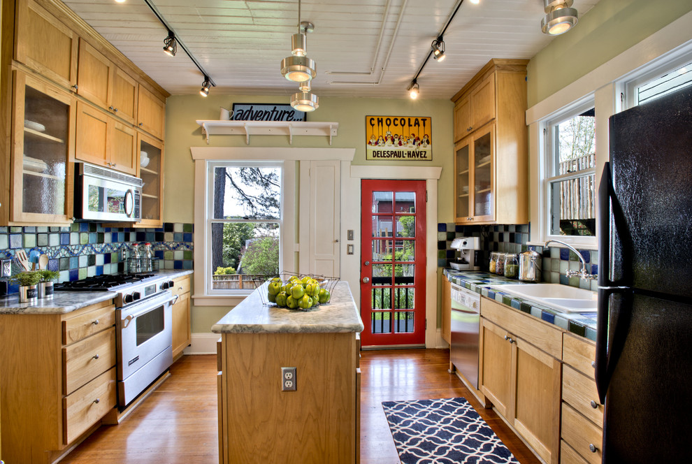 Traditional galley kitchen in Seattle with a double-bowl sink, shaker cabinets, medium wood cabinets, tile benchtops, multi-coloured splashback, stainless steel appliances, medium hardwood floors and with island.