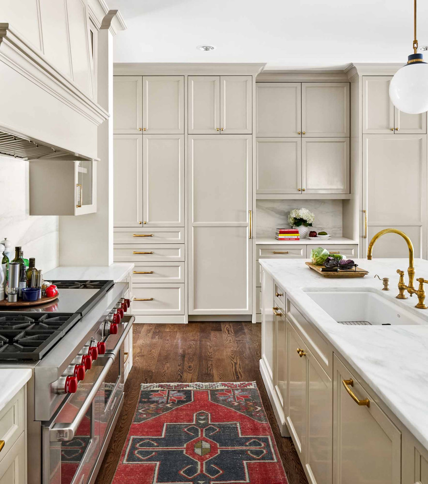 Expansive transitional kitchen in Austin with an undermount sink, recessed-panel cabinets, grey cabinets, marble benchtops, white splashback, marble splashback, stainless steel appliances, medium hardwood floors, with island, brown floor and white benchtop.