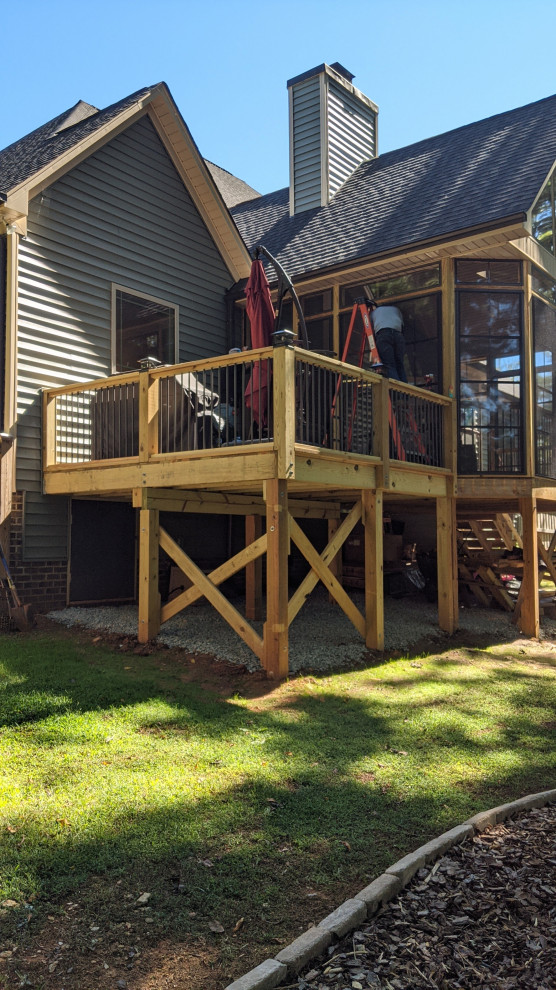 Inspiration for a mixed material railing deck remodel with a roof extension