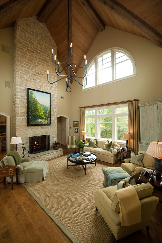 Design ideas for a large traditional living room in Charleston with beige walls, medium hardwood floors, a standard fireplace, a stone fireplace surround and no tv.