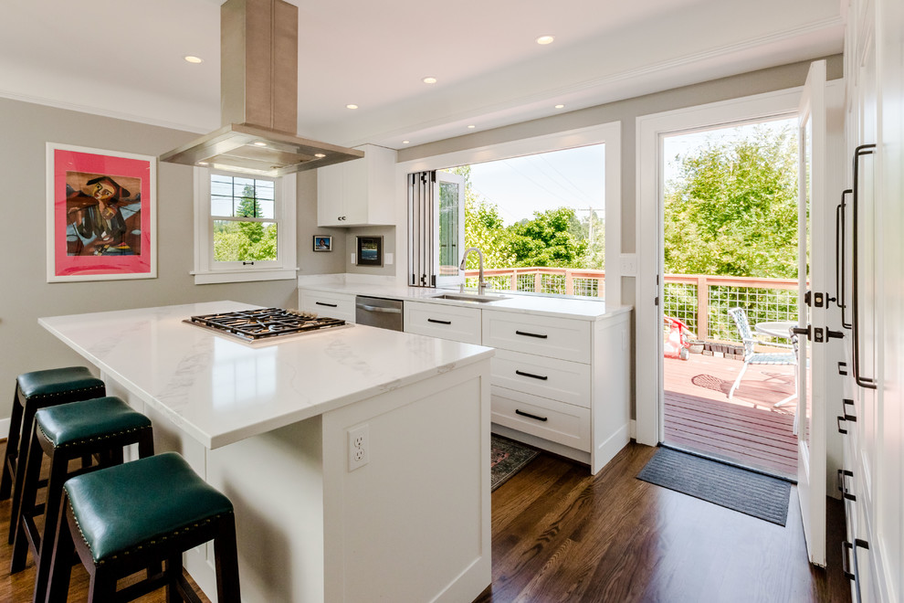 Inspiration for a mid-sized transitional l-shaped dark wood floor and brown floor open concept kitchen remodel in Seattle with an undermount sink, shaker cabinets, white cabinets, quartz countertops, white backsplash, porcelain backsplash, stainless steel appliances and an island