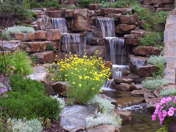 Photo of a huge rustic full sun backyard stone water fountain landscape in Denver for spring.