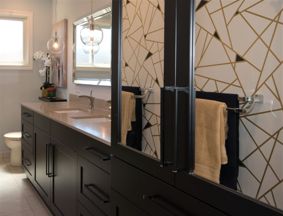 Example of a mid-sized transitional double-sink alcove bathtub design with recessed-panel cabinets, black cabinets, quartz countertops, a built-in vanity, an undermount sink, a hinged shower door and beige countertops