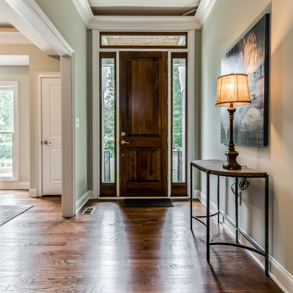 Photo of a transitional front door in Charlotte with green walls, dark hardwood floors, a single front door and a dark wood front door.