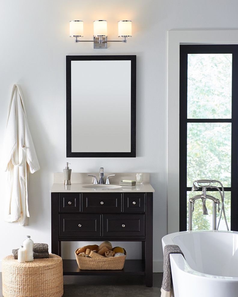 Example of a small transitional 3/4 freestanding bathtub design with black cabinets, white walls, a drop-in sink and laminate countertops