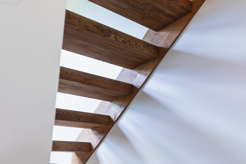 Diseño de escalera en U rústica de tamaño medio sin contrahuella con escalones de madera, barandilla de metal y madera
