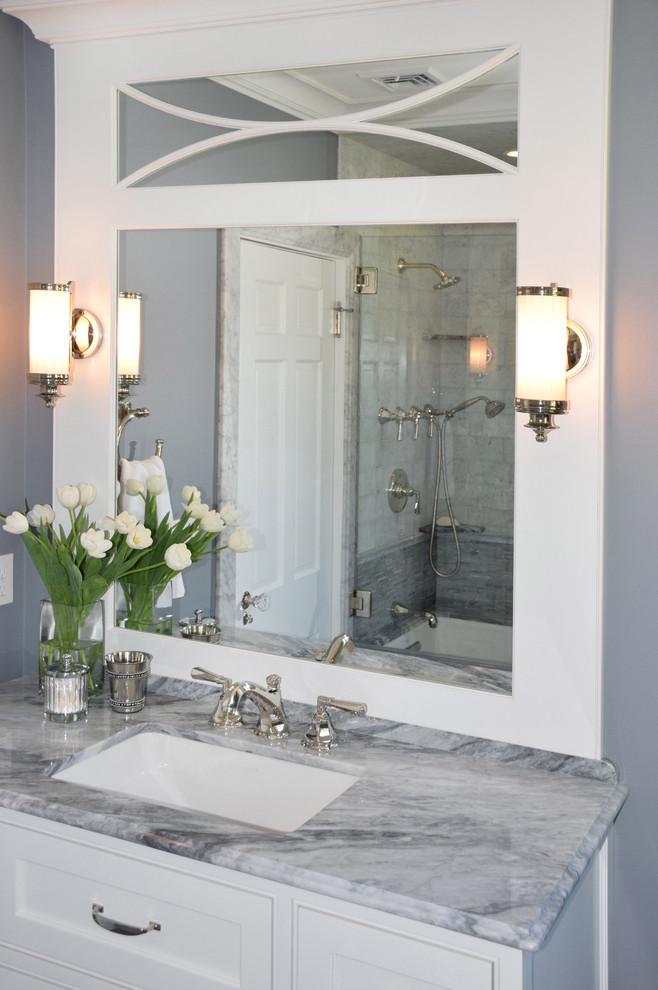 Inspiration for a large transitional 3/4 stone tile alcove bathtub remodel in Providence with beaded inset cabinets, white cabinets, blue walls, an undermount sink and marble countertops