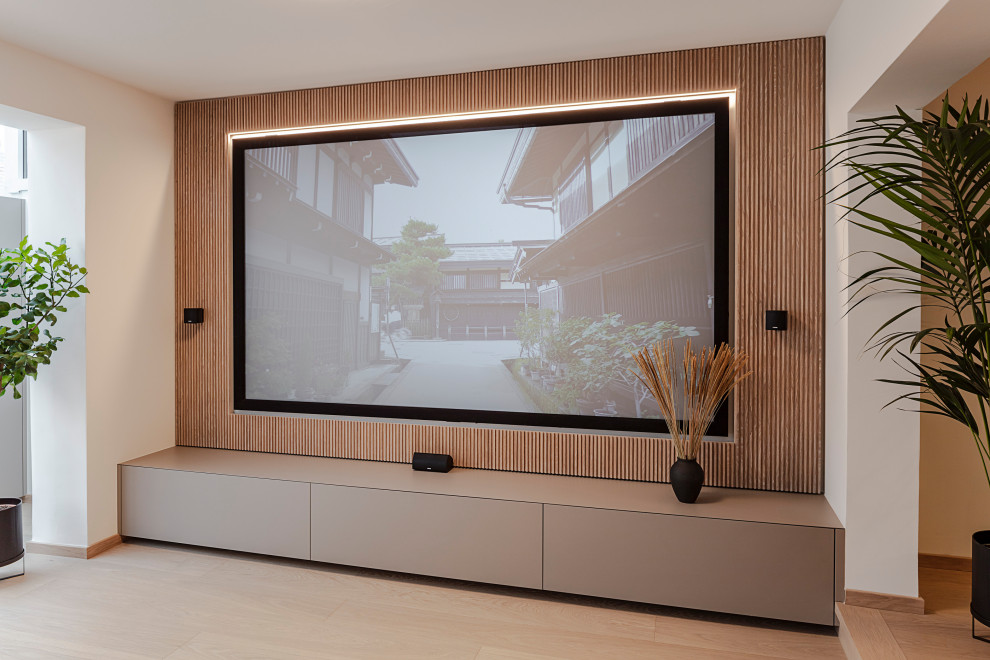 Diseño de sala de estar abierta de estilo zen grande con paredes beige, suelo de madera clara, pared multimedia y suelo beige