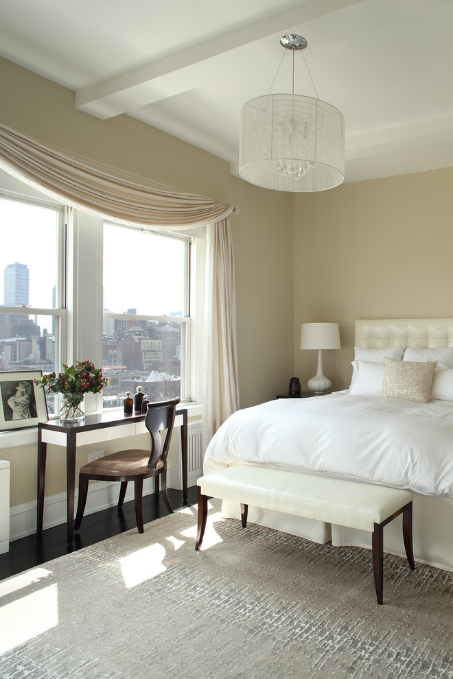 Traditional master bedroom in New York with beige walls and dark hardwood floors.