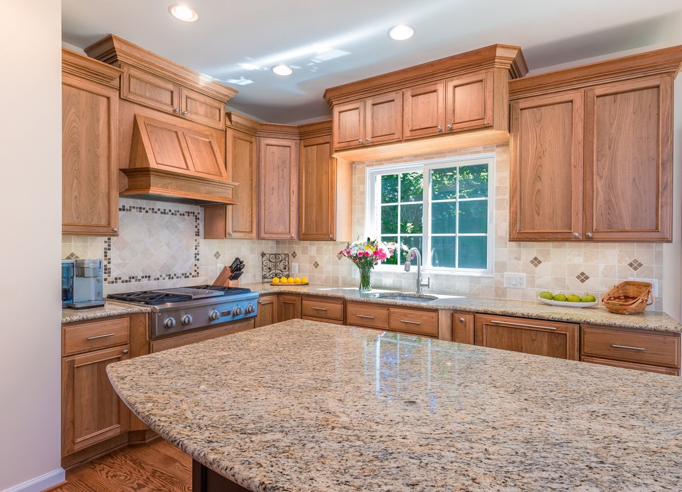 Photo of a large transitional u-shaped eat-in kitchen in DC Metro with an undermount sink, beaded inset cabinets, medium wood cabinets, granite benchtops, beige splashback, ceramic splashback, stainless steel appliances, medium hardwood floors and with island.