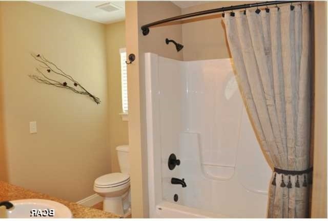 Design ideas for a mid-sized traditional master bathroom in Miami with flat-panel cabinets, medium wood cabinets, a freestanding tub, a shower/bathtub combo, a two-piece toilet, beige tile, porcelain tile, beige walls, porcelain floors, a drop-in sink and laminate benchtops.