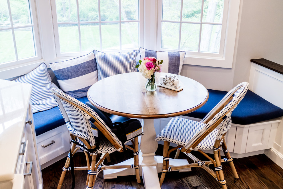 Mid-sized transitional dark wood floor and brown floor enclosed kitchen photo in New York with a farmhouse sink, recessed-panel cabinets, white cabinets, quartzite countertops, white backsplash, subway tile backsplash, stainless steel appliances and an island
